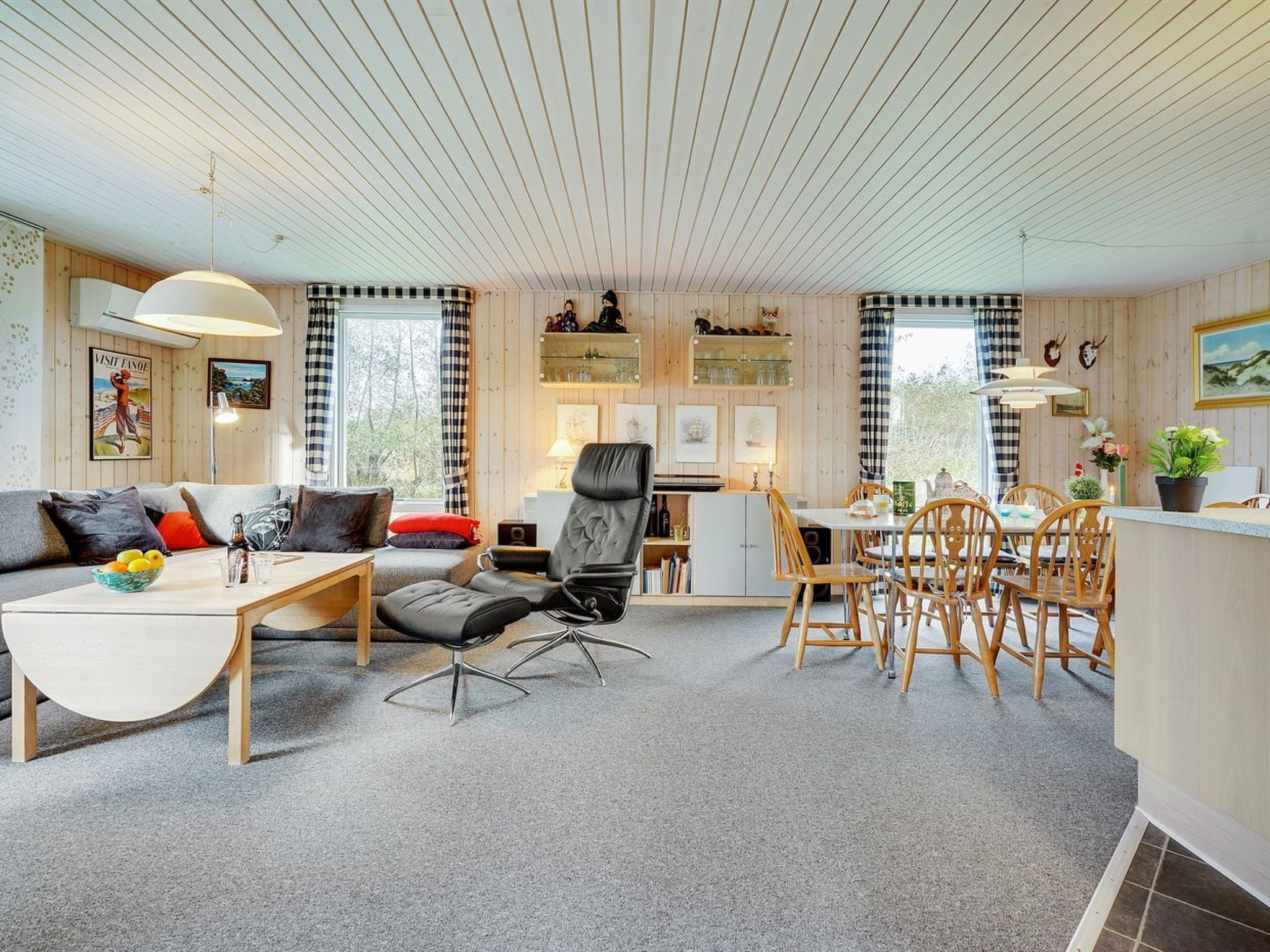 Ein stilvolles, helles Wohnzimmer mit einer Couch, einem Couchtisch und einem Essbereich.