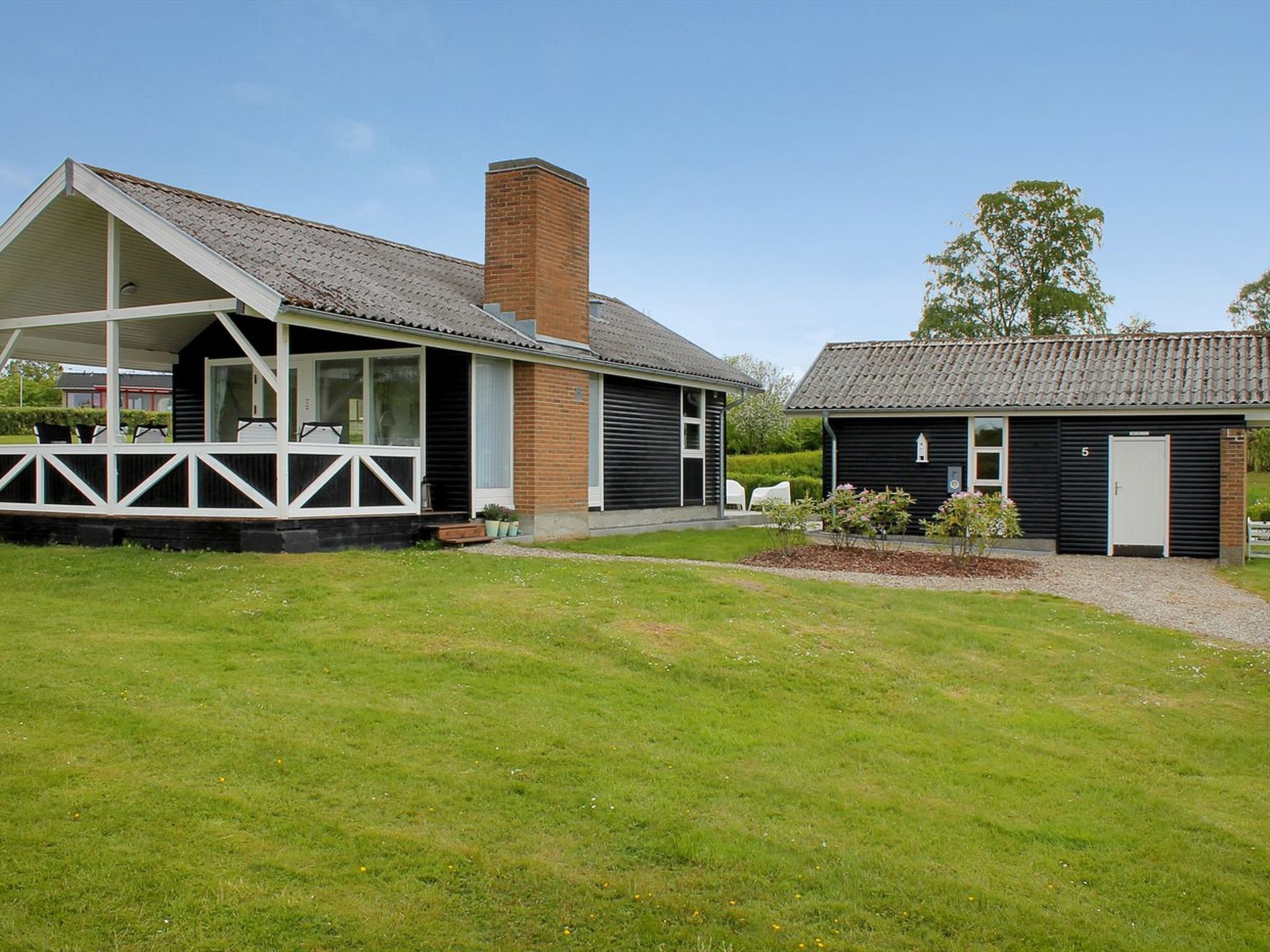 A two-story building with a covered porch and a separate garage.