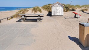 A beach with a wooden bench, a small shed, and a lifeguard tower. - "Eleen" - 100m to the fjord by Interhome (Vestervig)