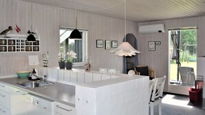 A modern kitchen with a central island, white cabinetry, a built-in sink, and pendant lighting. - "Kustaa" - 1km from the sea by Interhome (Humble)