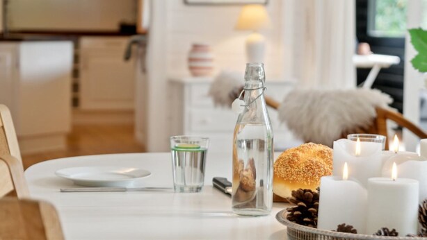 A dining table with a bottle, a glass, a bun, candles, and pine cones. - "Nititzki" - 600m from the sea by Interhome (Nykøbing Sj)