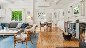 A spacious living area with a wooden floor, a dining table, and a fireplace. - "Nititzki" - 600m from the sea by Interhome (Nykøbing Sj)