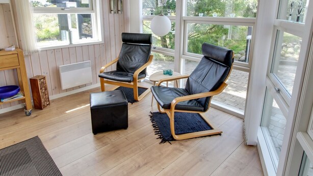 A cozy room with two leather chairs, a small table, and a window overlooking greenery. - "Aatos" - 500m from the sea by Interhome (Fanø)