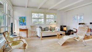 A spacious living room with a large window, a fireplace, and a cozy seating area. - "Bernadeta" - 1.2km from the sea by Interhome (Blokhus)