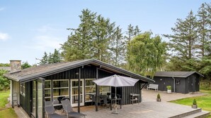 A modern house with a deck, outdoor seating, and a large umbrella. - "Bernadeta" - 1.2km from the sea by Interhome (Blokhus)