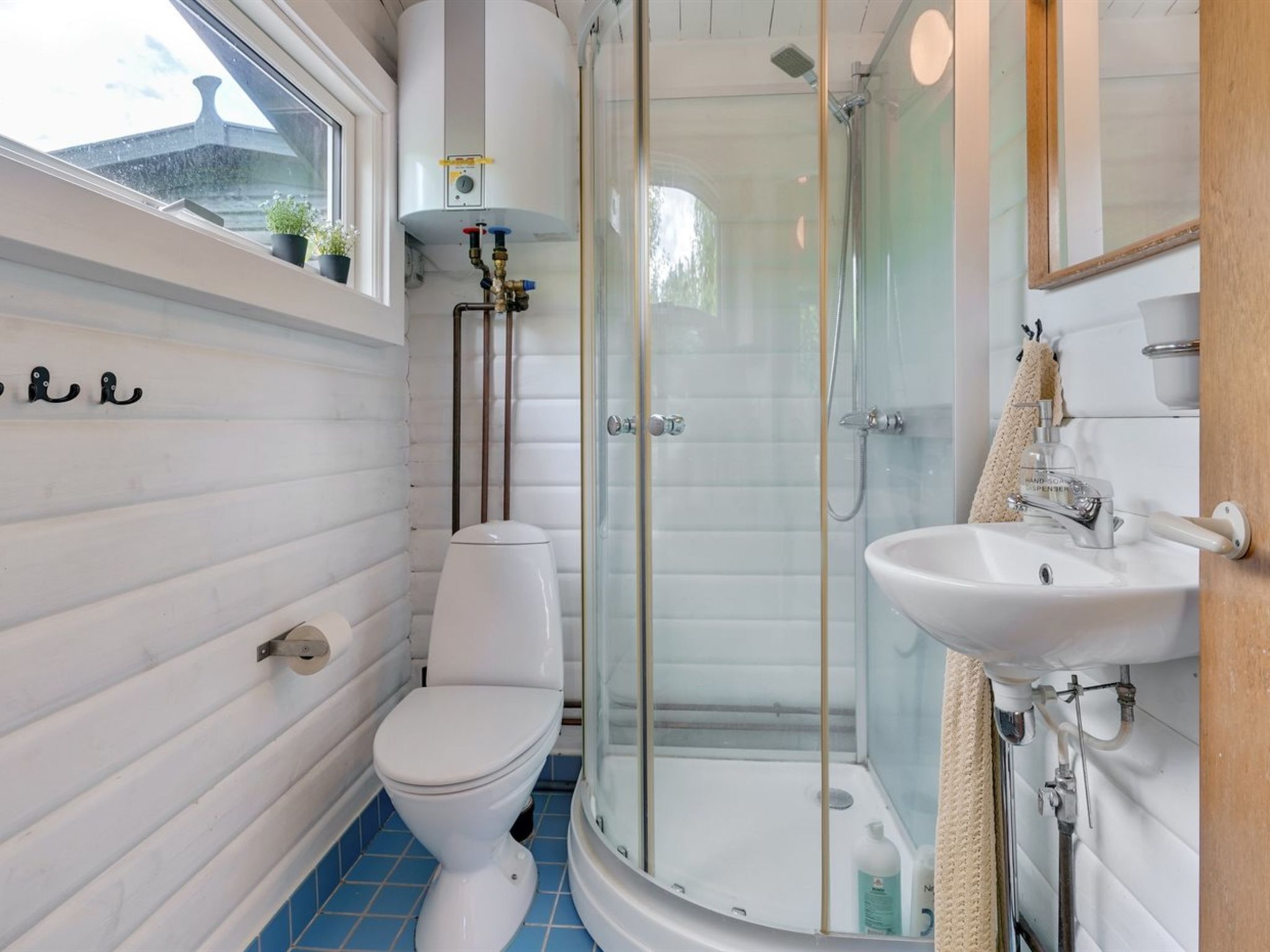 A modern bathroom with a toilet, shower, and sink.