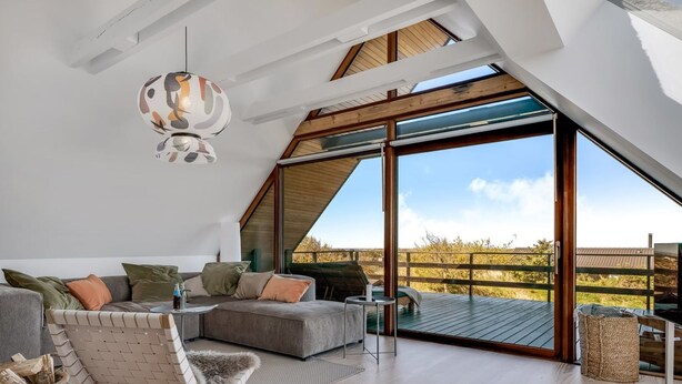 Um quarto amplo no estilo loft, com um amplo claraboia, um espaço de estar aconchegante e vista para o exterior.