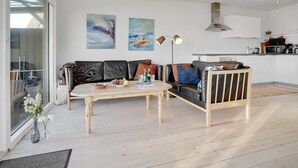 Una sala de estar moderna con un sofá, una mesa de centro y una obra de arte en la pared.