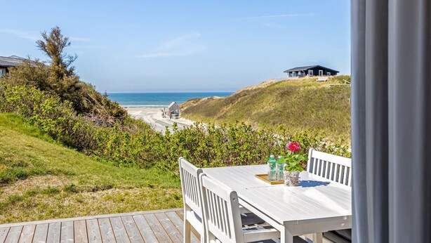 A seaside view from a deck with a table and chairs, overlooking the beach and ocean. - "Doritea" - 50m from the sea by Interhome (Løkken)