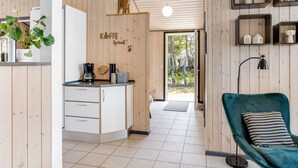 Een moderne keuken met houten wanden, een koffieapparaat en uitzicht op de achtertuin.