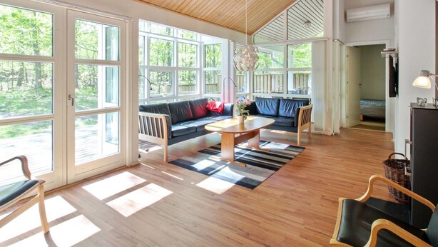 A spacious living area with a wooden ceiling, large windows, a sofa, a dining table, and a chair. - "Verner" - 500m from the sea by Interhome (Hasle)