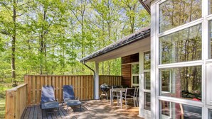 A deck with outdoor furniture, a grill, and a view of the surrounding forest. - "Verner" - 500m from the sea by Interhome (Hasle)