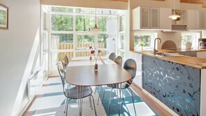 A modern kitchen with wooden cabinets, a built-in island, and a large window providing natural light. - "Verner" - 500m from the sea by Interhome (Hasle)