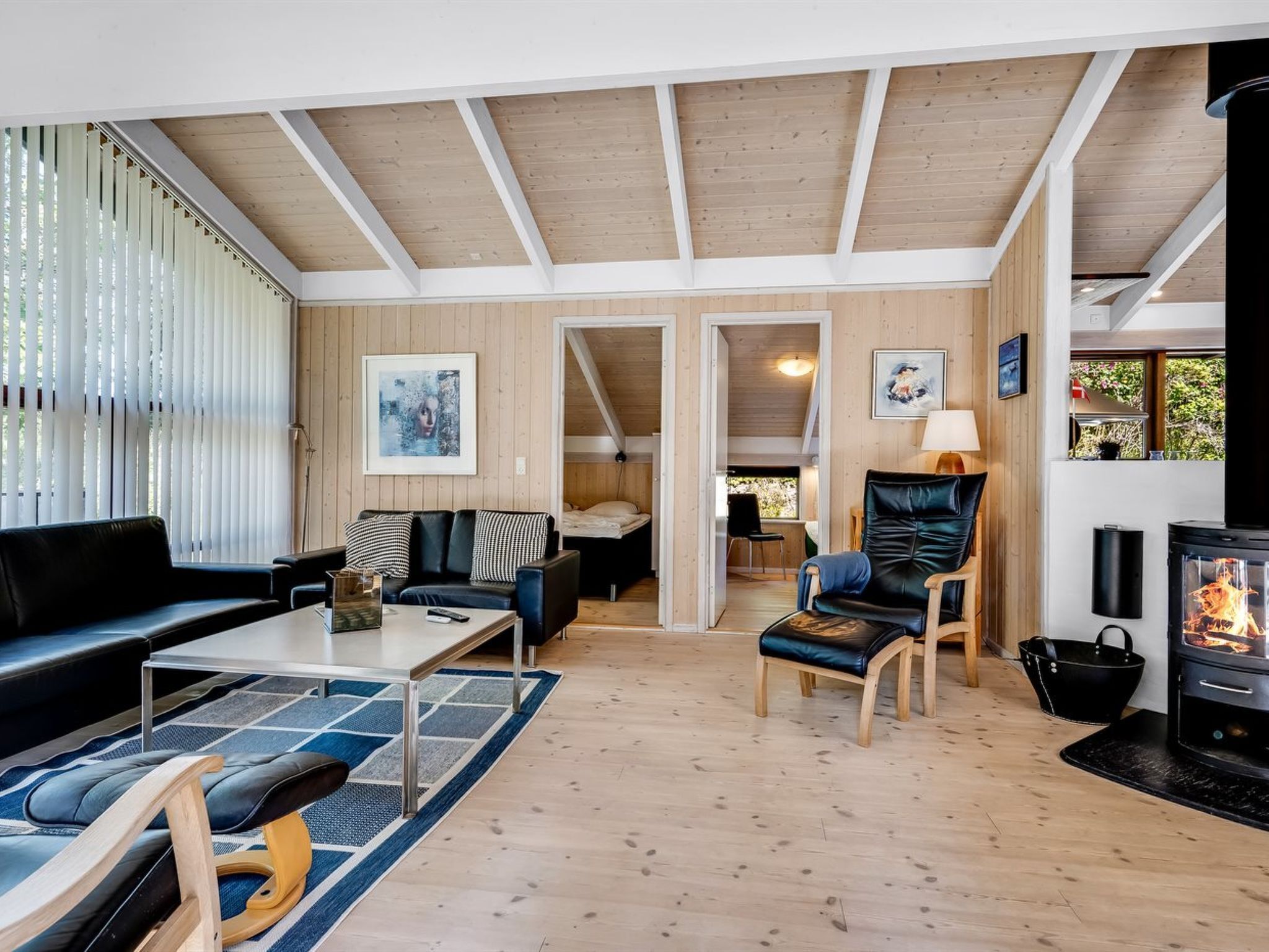 Un salon moderne doté d’une cheminée, de parquets en bois et d’un coin salon confortable.