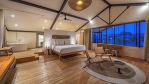 A spacious bedroom with a large bed, wooden flooring, a ceiling fan, and a view of the outdoors through large windows. - Villa Elma - 2BR pool villa in Umalas (Kerobokan)