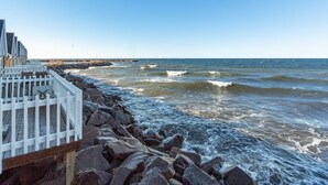 A rocky shoreline with a white fence and a pier extending into the water. - "Halldora" - 10m from the sea by Interhome (Hasle)