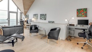A modern office space with a high ceiling, large windows, and a view of the sea. - "Halldora" - 10m from the sea by Interhome (Hasle)