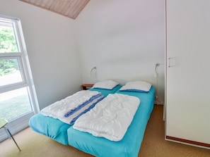 Quarto com duas camas, uma janela e uma porta.