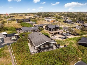 Un quartier résidentiel composé de plusieurs maisons, dont certaines sont dotées de garages attenants et d’espaces extérieurs aménagés pour se détendre.