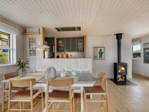 Un intérieur chaleureux comprenant un coin repas, une cuisine et un poêle à bois.