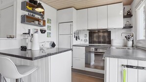 A modern kitchen with white cabinetry, a granite countertop, and stainless steel appliances. - "Anisa" - 400m from the sea by Interhome (Haderslev)