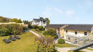 A residential building with a large lawn, a staircase, and a pool area.