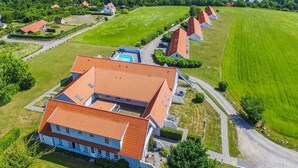 Vue aérienne d’un quartier résidentiel avec des maisons, une piscine et un grand espace vert.