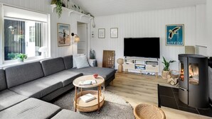 A modern living room with a sofa, TV, and fireplace.