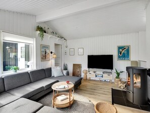 A modern living room with a sofa, TV, and fireplace.