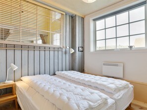 Una habitación con cama, ventana y radiador.