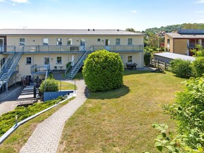 A building with multiple floors, outdoor seating, and a well-maintained lawn.