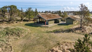 A remote cabin with a covered porch and a separate shed, surrounded by open fields and sparse trees. - "Alfrik" - 900m from the sea by Interhome (Blokhus)