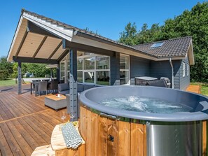 A modern outdoor deck with a hot tub, outdoor seating, and a covered patio area. - "Alrike" - 850m from the sea by Interhome (Grenaa)
