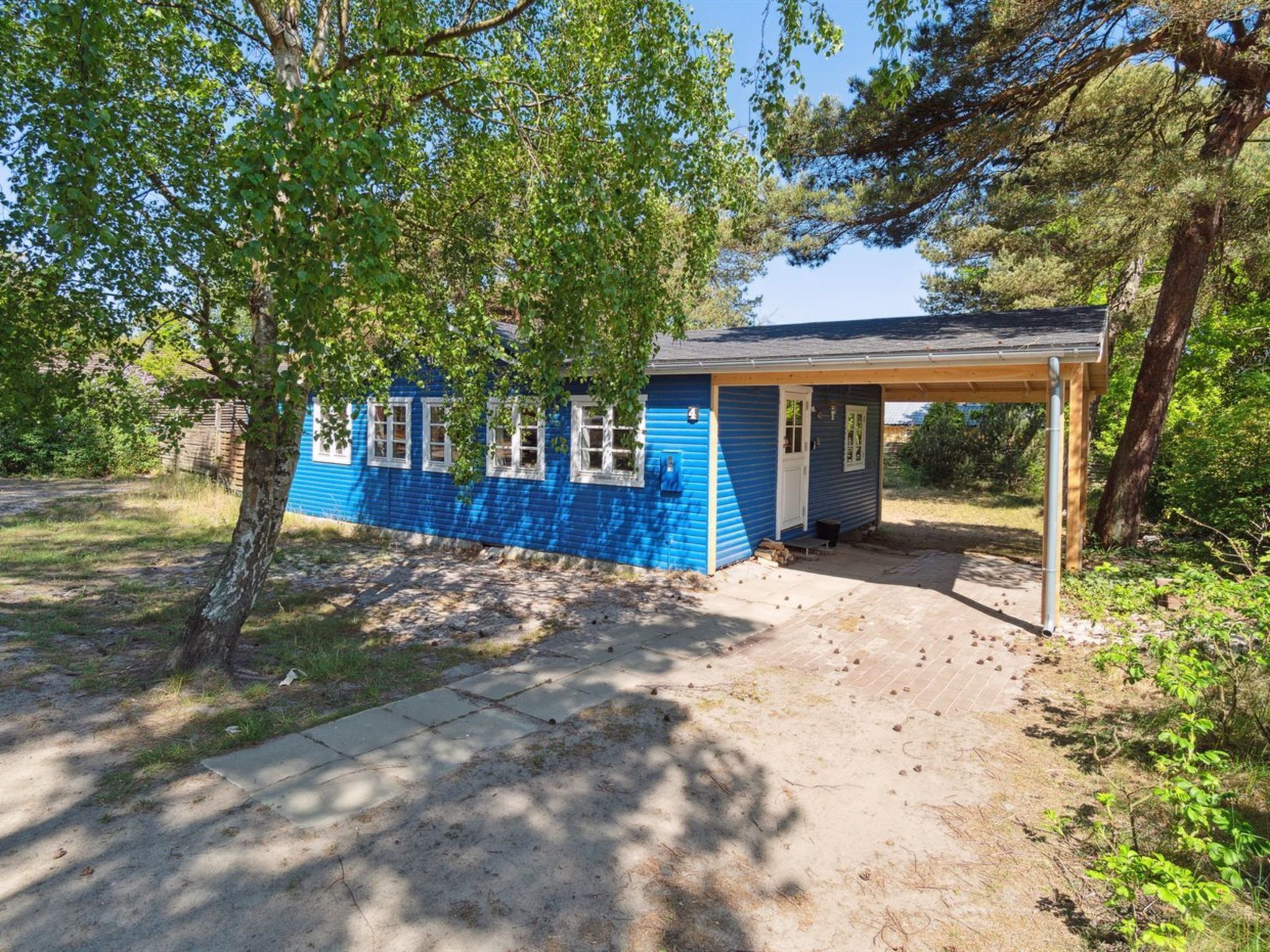 A small, single-story building with a blue exterior and a covered porch.