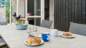 Een eettafel met borden croissants, een blauwe mok en zoutstrooiers.