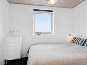 A bedroom with a bed, a dresser, a window, and a lamp. - "Mumme" - 100m from the sea by Interhome (Hals)