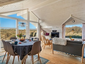 A spacious room with a dining area, a sofa, and a television.