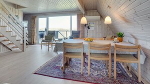 Een gezellig eetgedeelte met een houten tafel, vier stoelen en een vloerkleed.