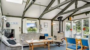 Un salon chaleureux avec un canapé, des fauteuils, une table et une cheminée.