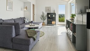 Una sala de estar moderna con un sofá gris, una mesa de centro y una estantería.