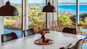 Un comedor con una mesa, sillas y un jarrón de flores.