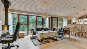 A spacious living area with a large window, a sofa, a coffee table, and a fireplace.
