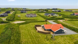 A residential area with houses, grassy lawns, and a clear sky.