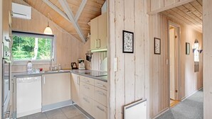 Een moderne keuken met houten wanden, een raam en een klok.