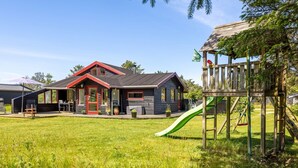 A wooden house with a red door and a play area with a slide. - "Gullborg" - 800m from the sea by Interhome (Løkken)