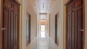 A hallway with wooden doors and tiled flooring.