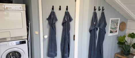 A laundry area with a washing machine and a drying rack against a door.
