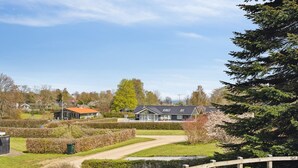 Un quartier résidentiel avec un chemin pavé, une clôture en bois et des maisons aux toits inclinés.