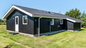 Un bâtiment en métal noir avec une porte blanche, une petite fenêtre et le numéro 18 peint sur le côté.