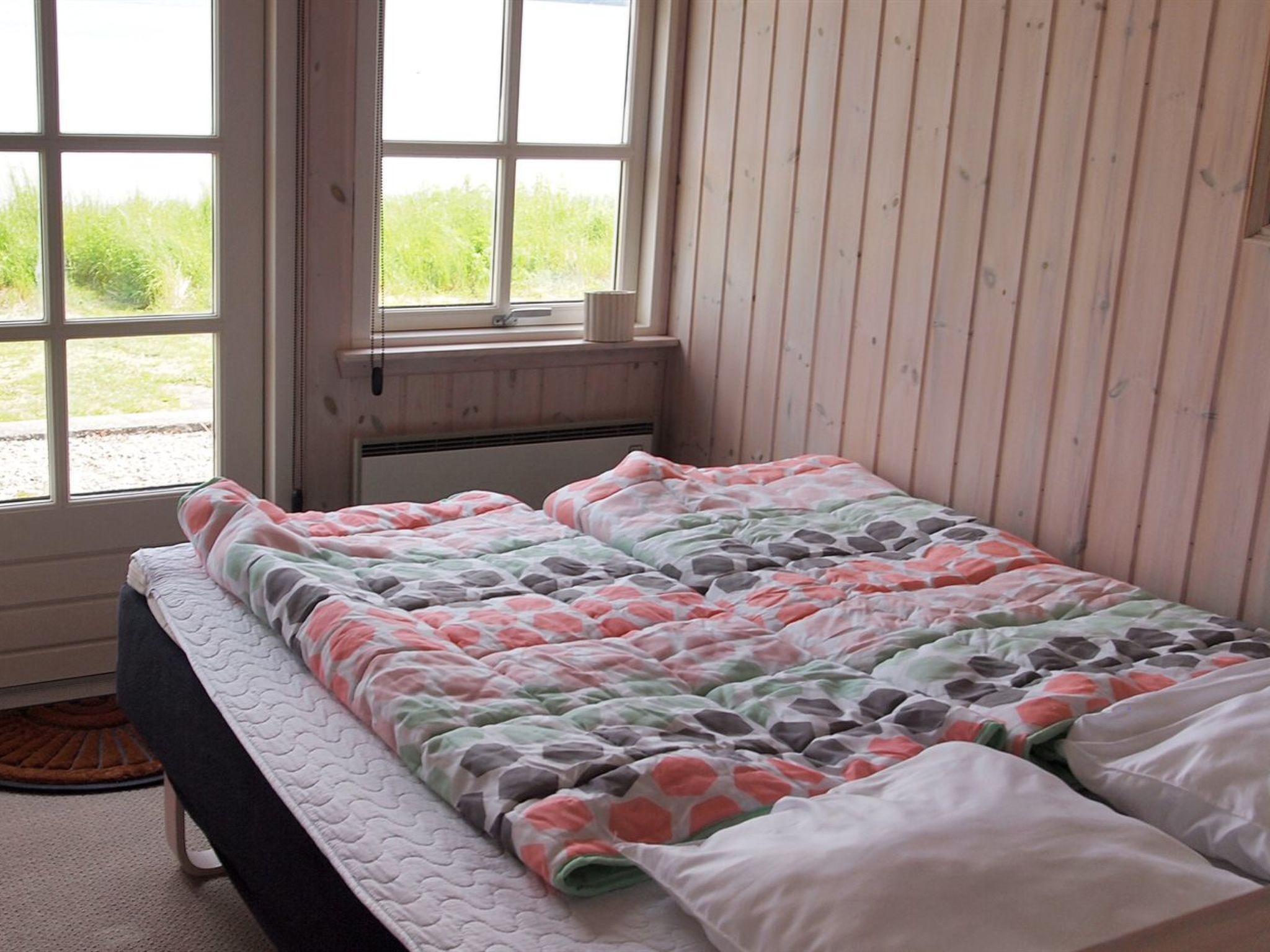 Une chambre à coucher avec un lit, une fenêtre et un radiateur.
